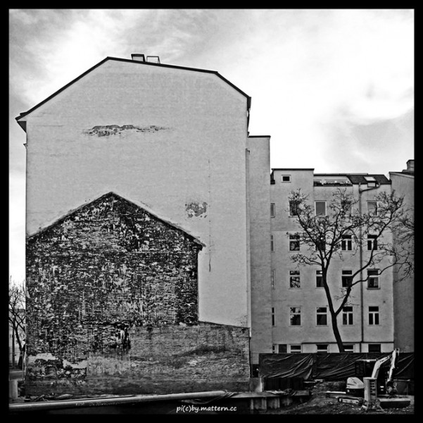 Schwarz-Weiß Bild: Kahle Hauswand mit Abbruchhaus und kahler Baum